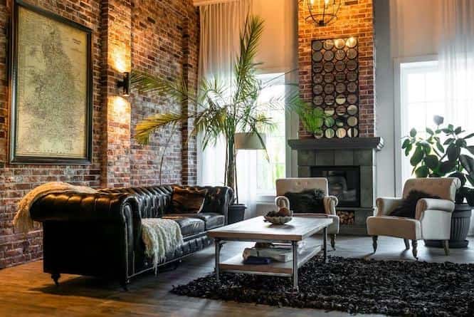 A stylish living room with exposed brick walls, a leather sofa, and elegant decor, offering interior design tips based on New Jersey’s housing styles for a cozy and modern home.